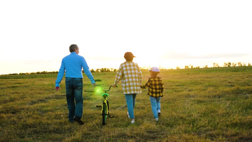Mum and dad with youngster enjoy stroll with bike in nature. Inquisitive kid explores hidden trails of countryside with parents on sunny day. Active family weekend in rural area during summer season | Shutterstock HD Video #1112071815