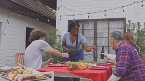 Multi-ethnic family having fun, enjoy party outdoors in the garden. Attractive diverse group of people having dinner, eating foods, celebrate weekend reunion gathered together at the dining table.
 - Powered by Shutterstock - Get 15% off with code: PIKWIZARD15