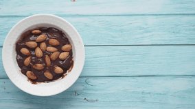 dark chocolate cream pouring on almond nut on white  - Powered by Shutterstock - Get 15% off with code: PIKWIZARD15