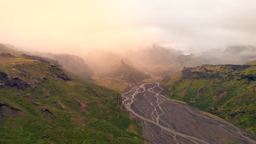 Iceland Thorsmork Beautiful Sunrise Warm Light Fantasy Game of Thrones Location. River Braids Green Mountains Pointed Natural Formation. Drone Though Valley with Thick Fog Clouds. High Quality Color C