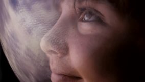 Portrait of a cute boy with big eyes happily looking at planet earth wearing a spacesuit helmet and looking through the glass from outer space. A teenager studies space. Spaceship simulator - Powered by Shutterstock - Get 15% off with code: PIKWIZARD15