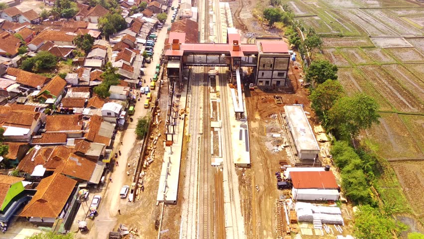 Drone Footage. Established Aerial View of Cicalengka Station, with trains, buildings, crowded vehicles traffic in morning sunlight. Shot in 4k resolution from a flying drone. Bandung - Indonesia, Asia