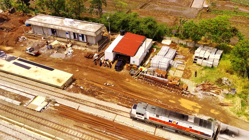 Transportation Footage. Established Aerial View of The train arrives and stops at Cicalengka station during the day. Shot in 4k resolution from a flying drone. Bandung - Indonesia, Asia