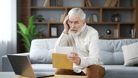Disappointed elderly senior gray haired man reading letter with bad news sitting on sofa at home. Sad adult mature male is depressed by an unpleasant notification, shocked by information in document - Powered by Shutterstock - Get 15% off with code: PIKWIZARD15