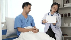 Young Asian female doctor and young male patient lying on bed while checking pulse Consult and explain with nurses taking notes and helping Video 4k