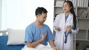 Young Asian female doctor and young male patient lying on bed while checking pulse Consult and explain with nurses taking notes and helping Video 4k