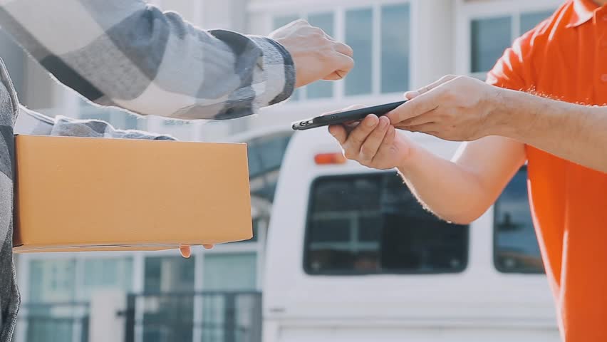 Fast and reliable service. Cheerful young delivery man giving a cardboard box to young woman while standing at the entrance of her apartment
 Royalty-Free Stock Footage #1112101651