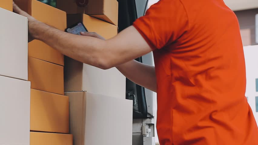 Fast and reliable service. Cheerful young delivery man giving a cardboard box to young woman while standing at the entrance of her apartment
 Royalty-Free Stock Footage #1112101657