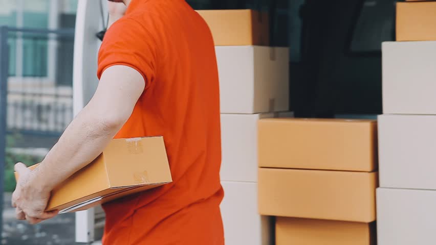 Fast and reliable service. Cheerful young delivery man giving a cardboard box to young woman while standing at the entrance of her apartment
 Royalty-Free Stock Footage #1112101685
