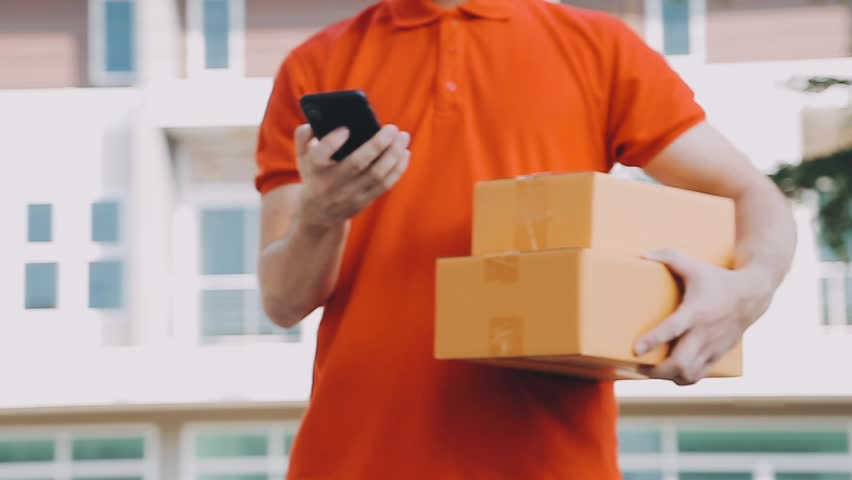 Fast and reliable service. Cheerful young delivery man giving a cardboard box to young woman while standing at the entrance of her apartment
 Royalty-Free Stock Footage #1112101687