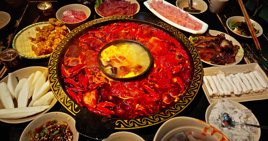 Chinese spicy hot pot cuisine. A layer of red chili pepper floats in the boiling hot pot base. Famous Chongqing Spicy Hot Pot, China.