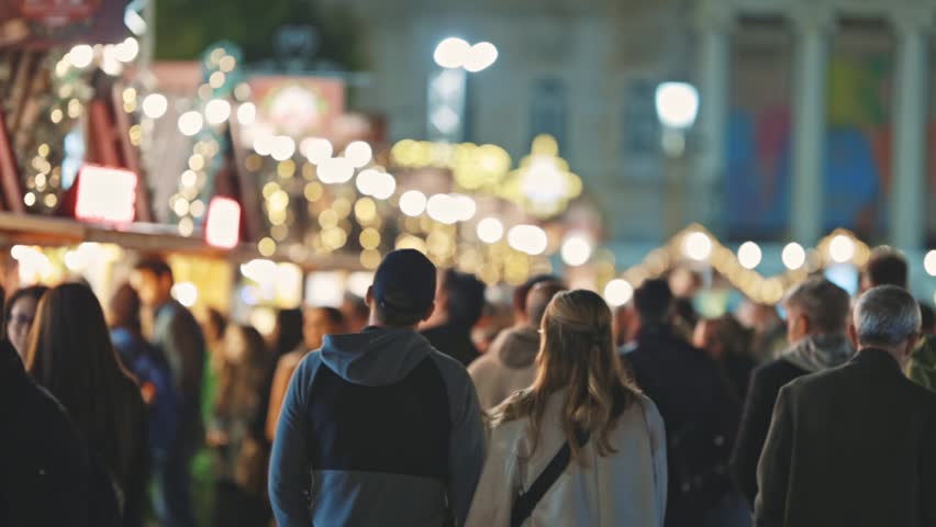 A Festive Night: Christmass Crowd Walking Down a Street at Night