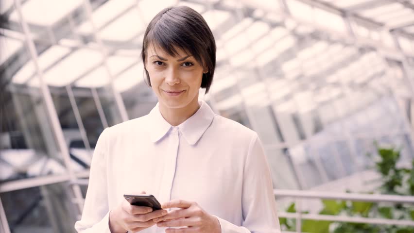 Friendly businesswoman beams at camera in bright surrounding Royalty-Free Stock Footage #1112104507