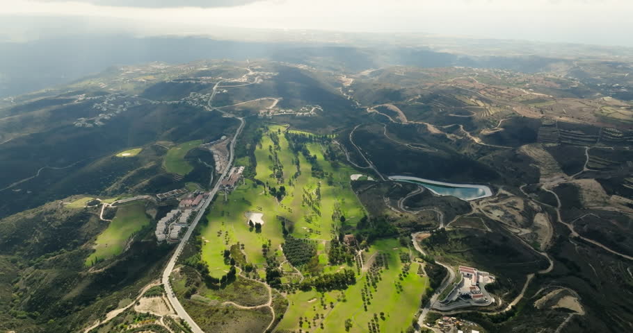 Flying High over Golf Paradise: Aerial Landscape of Majestic Mountains and Relaxing Pastimes. High quality 4k footage