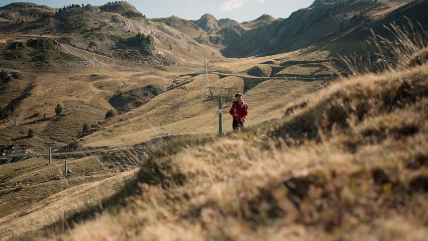 Young woman with backpack hiking in rolling landscape
