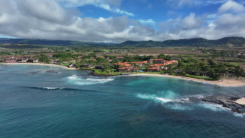 Aerial Kauai Hawaii Poipu Beach beach surfing slide 1. Surfing and swimming tourist Hawaiian seascape recreation. Swimming and snorkeling areas, and reef surf. Luxury resorts and restaurants.