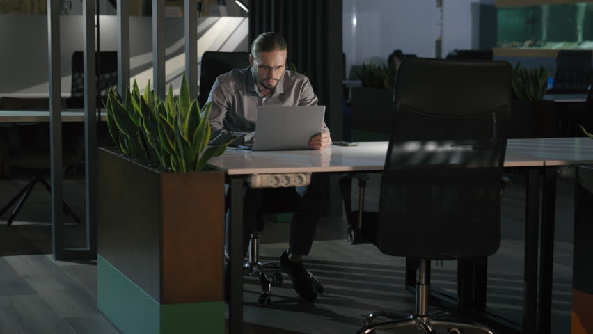 Serious concentrate focused Caucasian businessman in glasses dark evening night office hard working manager male company boss job addict business man working computer late time looking at laptop zoom Royalty-Free Stock Footage #1112118119
