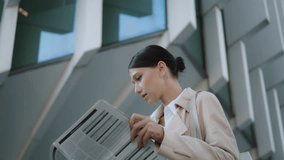 Young attractive woman turning newspaper pages standing alone outdoors close up. Confident businesswoman reading tabloid publication in news paper. Smart successful manager searching information. - Powered by Shutterstock - Get 15% off with code: PIKWIZARD15