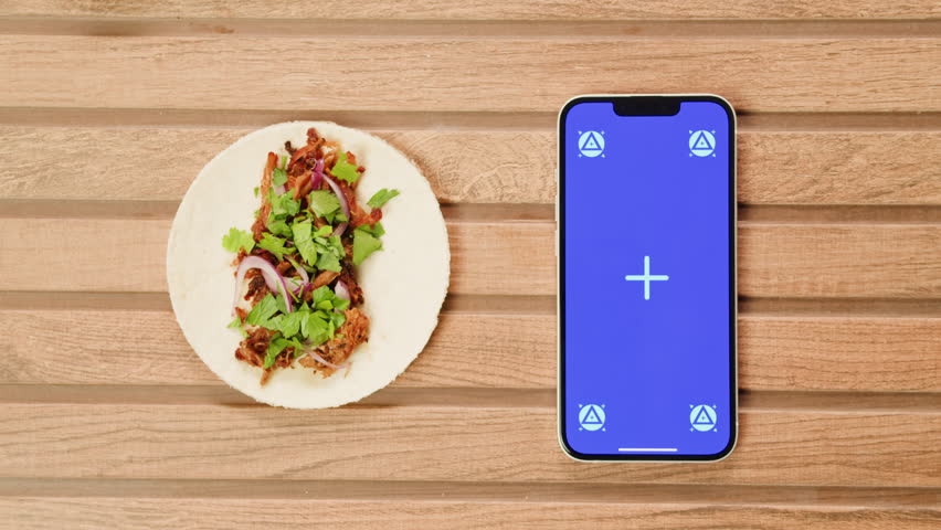 Tradition mexican tacos with mane various of meat and vegetables on the table top view . Phone with chroma key screen standing among homemade tacos  | Shutterstock HD Video #1112120577
