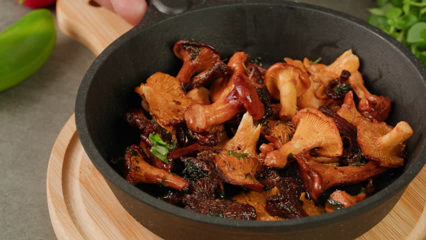 Fried chanterelle mushrooms decorate with basil and parsley in a metall pan and the ingredients cooking i9n restaurant adding soma sault, autumn menu in cafe. | Shutterstock HD Video #1112120599