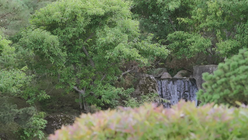 Waterfall flowing at the Japanese Gardens. Slow motion.