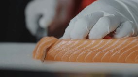 Female chef hand using fish fillet knife slice fresh orange salmon meat on cutting board in restaurant, Chef preparing healthy menu salmon sashimi or sushi to customer, Japanese cuisine recipes. - Powered by Shutterstock - Get 15% off with code: PIKWIZARD15