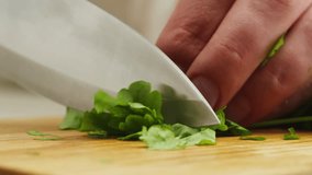 Cutting green cilantro parsley on wooden desk with knife close-up macro. Woman hand cut greens. Food healthy concept - Powered by Shutterstock - Get 15% off with code: PIKWIZARD15