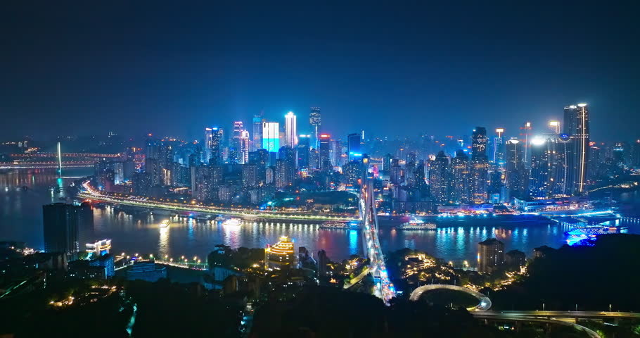 Aerial shot of city buildings skyline and river at night in Chongqing, China