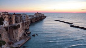 Awesome evening cityscape of Vieste - coastal town in Gargano National Park, Italy, Europe. Captivating spring sunset on Adriatic sea. Full HD video (High Definition).