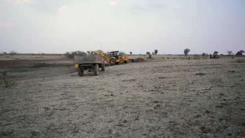 ANDHRA PRADESH, INDIA - CIRCA MAY 2013 - Earthworks with bulldozers and trucks, long shot, pan left