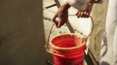 ANDHRA PRADESH, INDIA - CIRCA MAY 2013 - Draw water from a well with a bucket, close up, shallow DOF