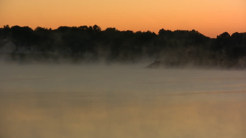 Mist and Fog moving across a lake at sunrise.