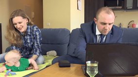 Happy family with newborn baby planning summer holiday finance budget. Woman wife with baby and man husband count money. Man take money from wallet. Working with computer at home. 4K UHD video clip.
