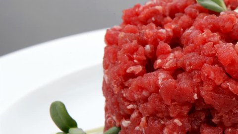 very big raw hamburger cutlet with sprouts and chilli pepper plate over black background 1920x1080 intro motion slow hidef hd