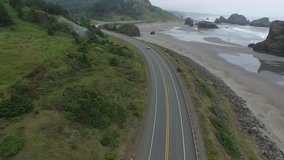 Aerial wide shot of a highway on the beach in oregon. Traveling through curry county oregon