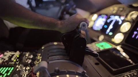 Detail shot of airline pilot pushing throttle forward in the cockpit of a jumbo jet.  Side view, hand-held camera, originally recorded in 4K.