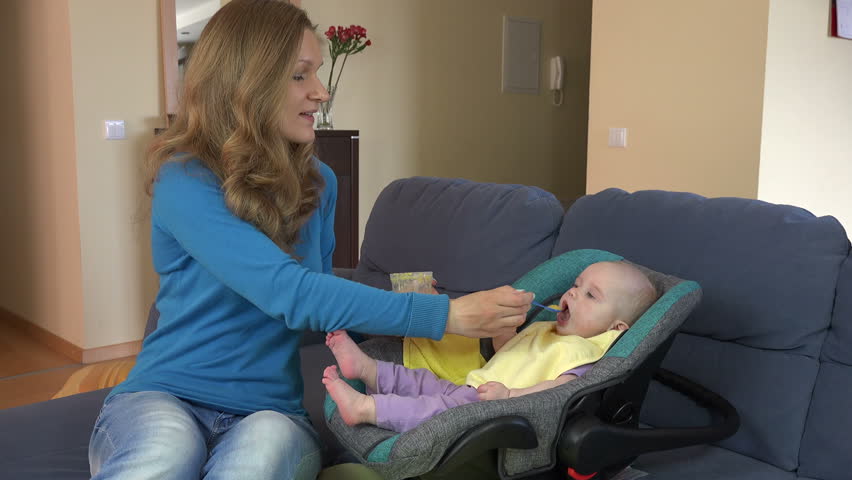 loving woman mother feeds daughter baby Stockvideoklipp (helt royaltyfria) ...
