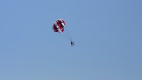Fun on the sea - people Flying with a parachute against the blue sky