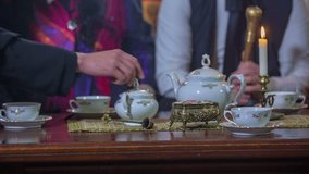 Man picking some sugar from the table to sweeten his tea in the vintage living room, historic close up RAW footage.