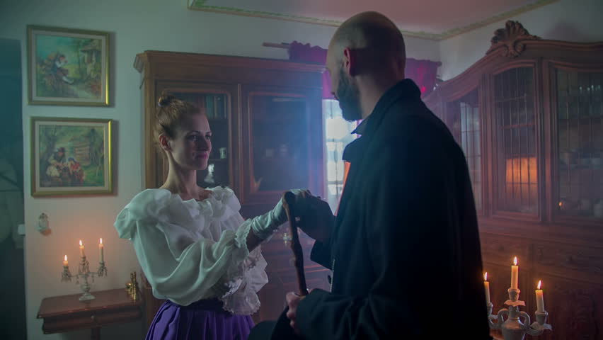 Man is complementing a beautiful woman before they are having a cap of tea in the historic house, vintage footage in slow motion.