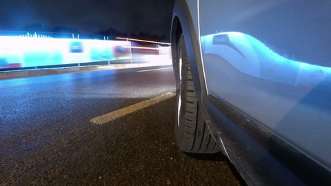 Time-lapse POV shot of a car driving through the city at night. Camera mounted on car's side facing front wheel.