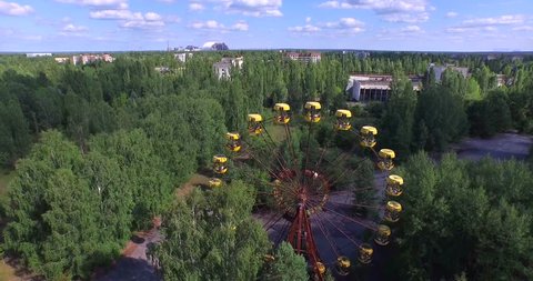 Aerial video.  A Ferris wheel in Pripyat, near Chernobyl.The giant Ferris wheel was never loaded. The park was only opened for one day, and almost immediately abandoned. Drone footage. 4K.