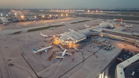 Timelapse.Aerial View.Airport Terminal at Sunset with Airplanes Taxiing and Landing.