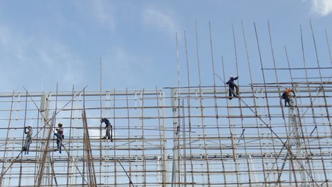 HONG KONG - AUGUST 18: Hong Kong construction worker erecting bamboo scaffolding on top of a tall building in Hong Kong. on August 18, 2011.
