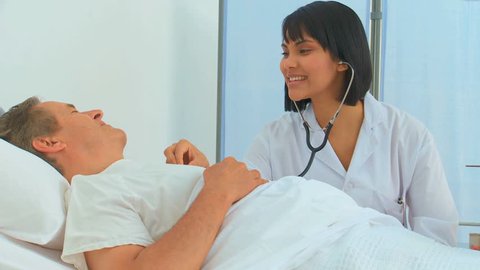 An Asian nurse using a stethoscope on her patient at the hospital, Healthcare workers in the Coronavirus Covid19 pandemic