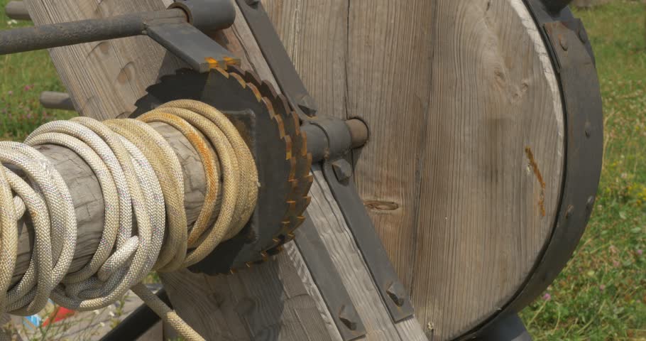Winches of the catapult, closeup, tilt up, fortress hill, fortress walls, woden walls, gray clouds, watchtowers, Kievan Russ, 11 Century, Reconstruction, Ancient Wooden Structures 10-11 centuries,