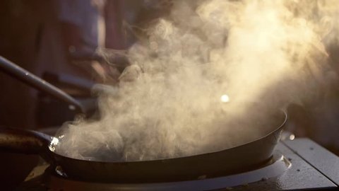 SLOW MOTION: cook makes asian noodles in wok. A versatile round-bottomed cooking vessel, originating from China. Asian food cooking.
