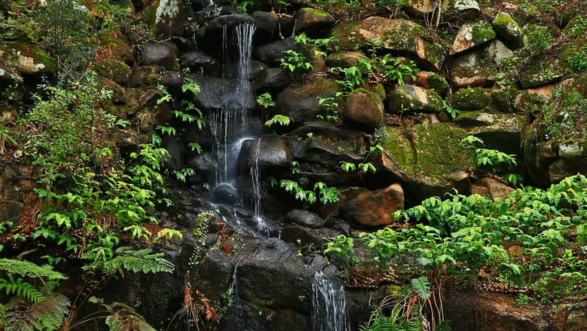 Small beautiful waterfall from brook and rock in park 