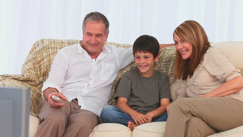 Cute family watching the tv on their sofa