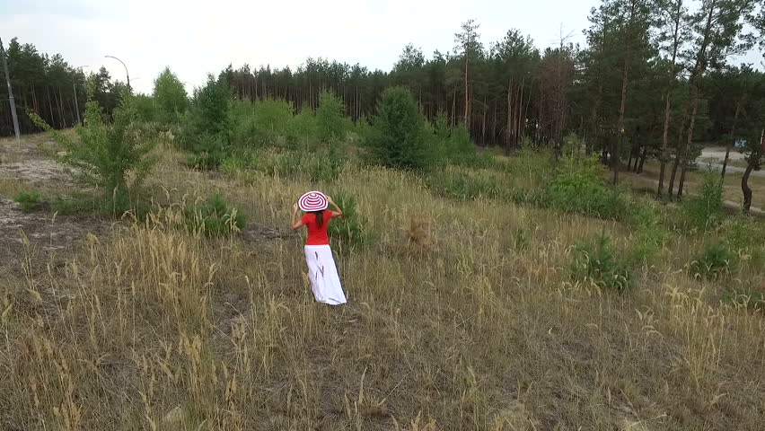 beautiful woman in a red shirt walking on the field
